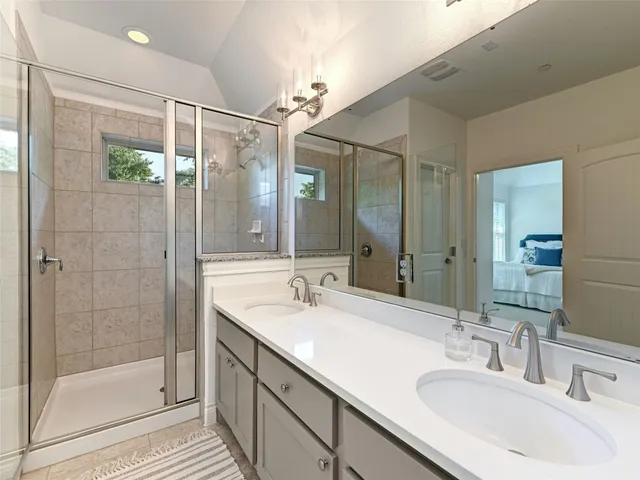 a bathroom with a shower sink and mirror