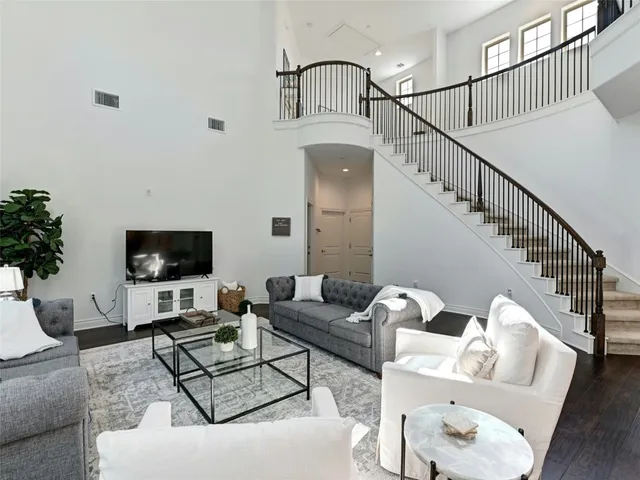 a living room with furniture flat screen tv and a potted plant