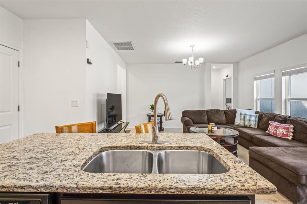 571 Old Windsor Way Spring Hill, FL 34609 - Photo 20 of 61 a kitchen with a granite countertop sink a stove and cabinets