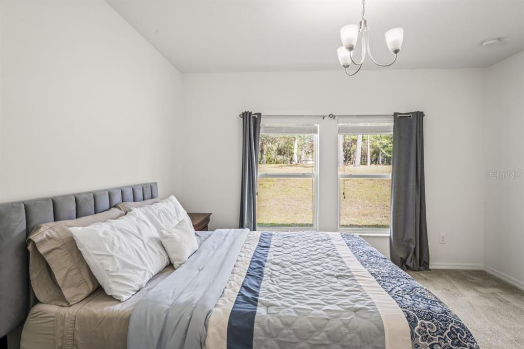 571 Old Windsor Way Spring Hill, FL 34609 - Photo 24 of 61 a bedroom with a large bed and a window