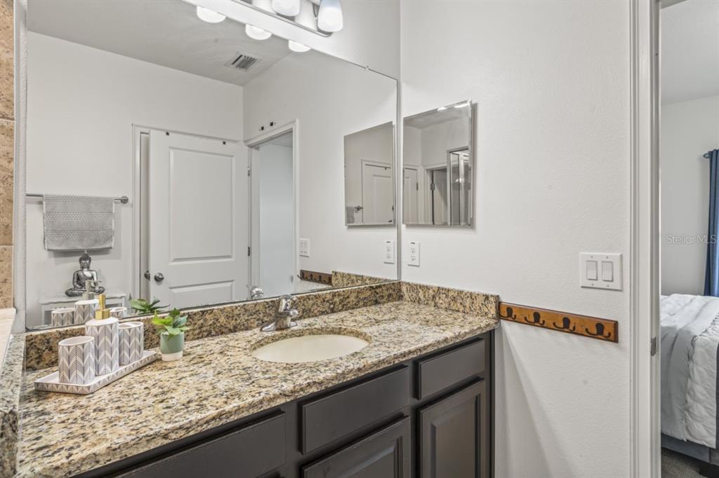 571 Old Windsor Way Spring Hill, FL 34609 - Photo 25 of 61 a bathroom with a granite countertop sink and a mirror