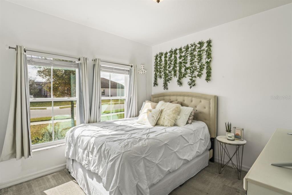 571 Old Windsor Way Spring Hill, FL 34609 - Photo 27 of 61 a large bed sitting in a bedroom next to a window