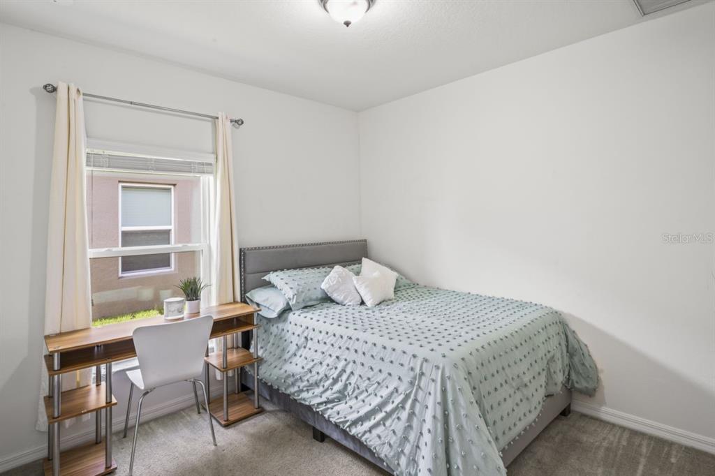 571 Old Windsor Way Spring Hill, FL 34609 - Photo 10 of 61 a bedroom with a bed and a table