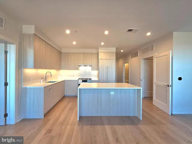 a large kitchen with kitchen island wooden floors wooden cabinets