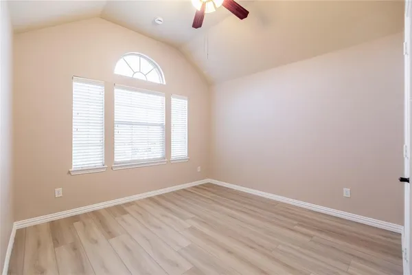 an empty room with a window and a fan