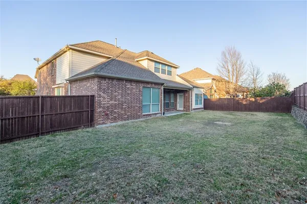 a view of a yard in front of a house with wooden fence