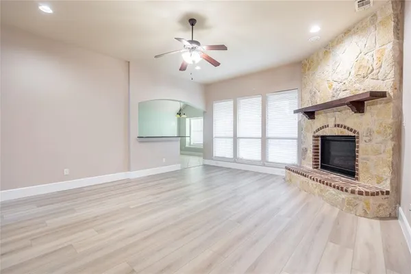 an empty room with windows and fireplace