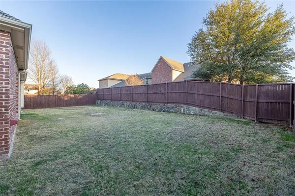 a view of a backyard with wooden fence