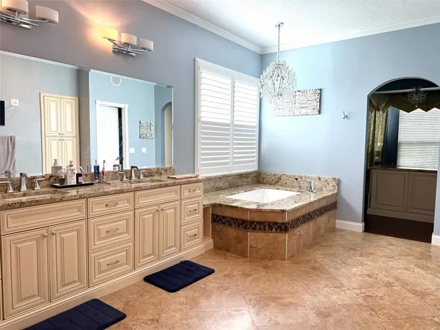 a spacious bathroom with a granite countertop sink a mirror and a bathtub