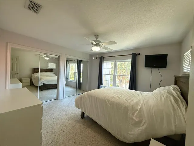 a bedroom with a bed and a large mirror