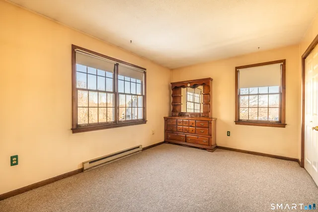 an empty room with mirror and windows