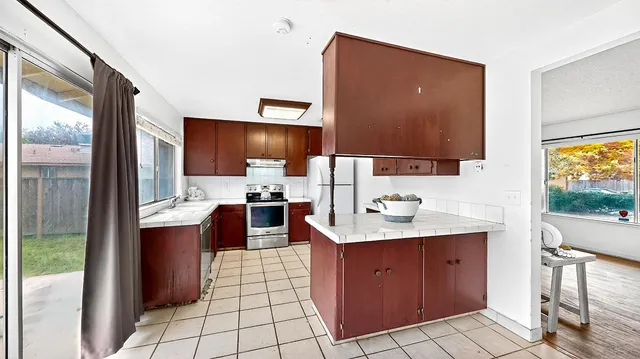 a kitchen with stainless steel appliances a sink cabinets and a wooden floor