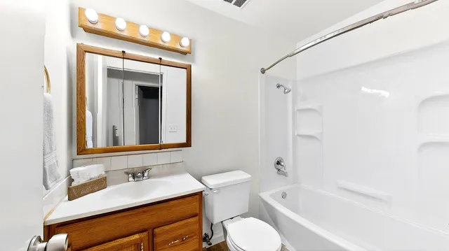 a bathroom with a granite countertop sink toilet and shower