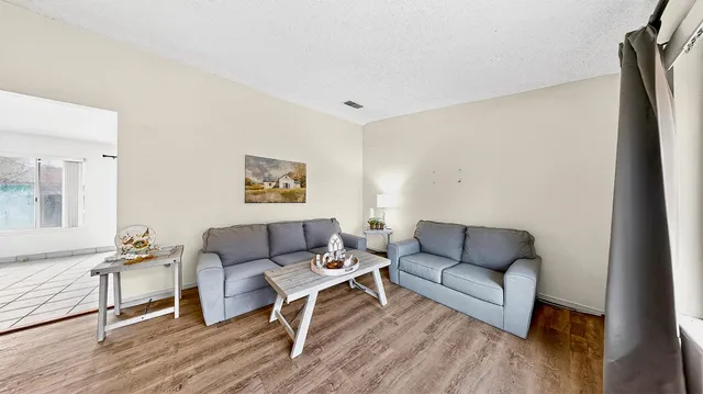 a living room with furniture and a wooden floor