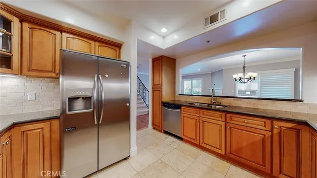 a large kitchen with stainless steel appliances granite countertop a refrigerator and a sink