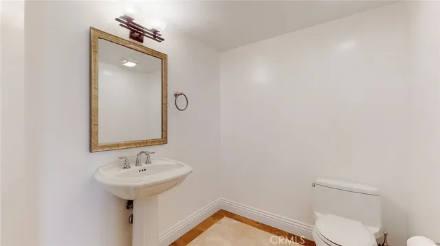 a bathroom with a sink toilet and mirror