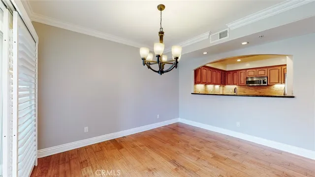 a view of a room with wooden floor and chandelier