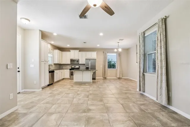 a view of a kitchen with a sink a refrigerator and window