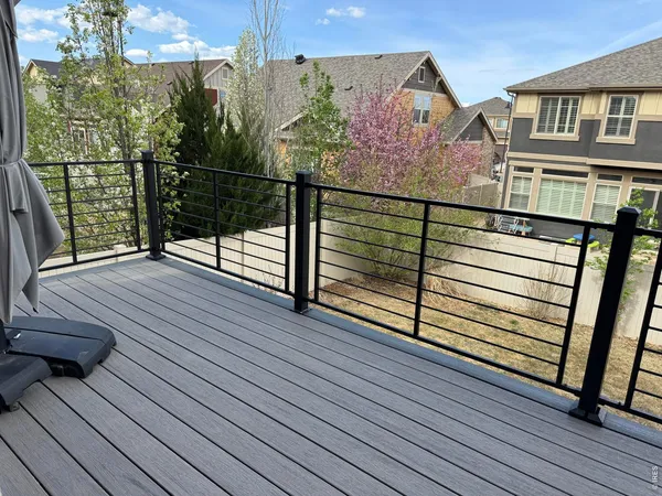 a view of a balcony with wooden floor and fence