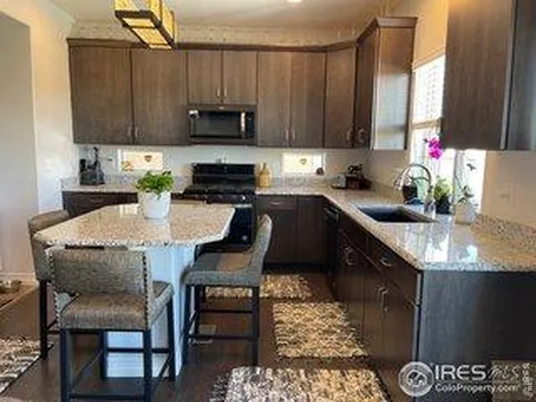 a kitchen with granite countertop a table chairs stove and cabinets
