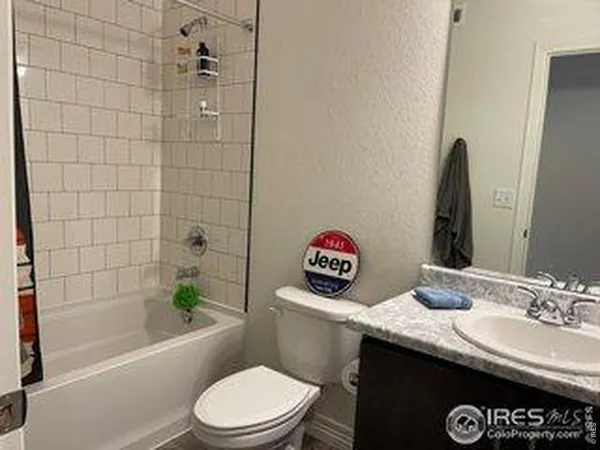 a bathroom with a granite countertop toilet a sink and a bathtub