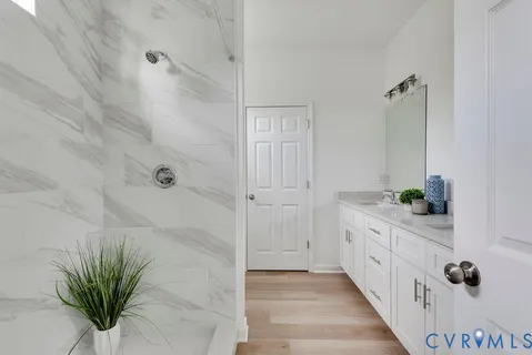 a bathroom with a granite countertop sink a mirror and a potted plant