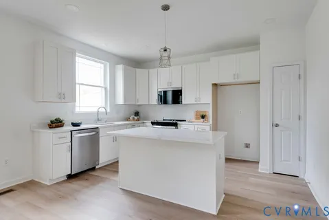 a kitchen with a refrigerator a stove a microwave and white cabinets