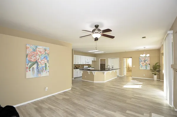 a view of a livingroom with a ceiling fan & windows
