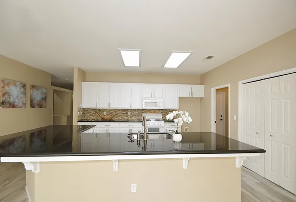 a view of a kitchen with kitchen island a sink a stove and a refrigerator