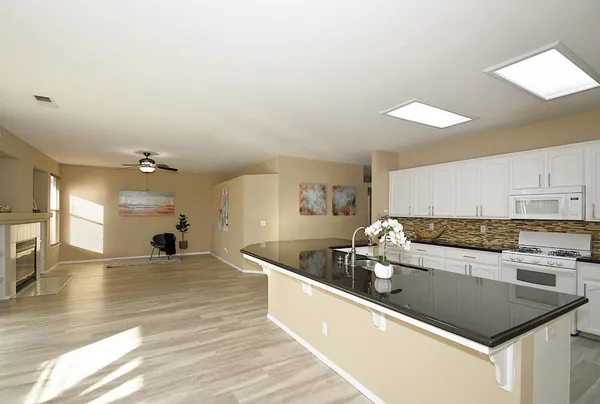 a kitchen with stainless steel appliances granite countertop a sink a stove and a refrigerator