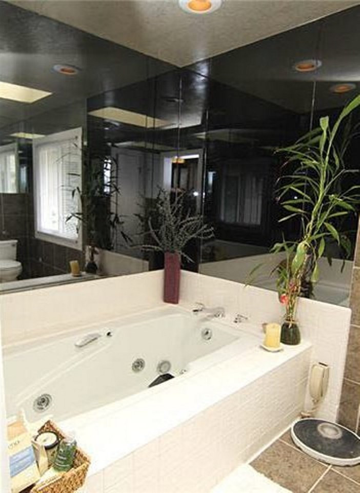6909 Slade Hill Road Raleigh, NC 27615 - Photo 15 of 25 Master bath has new vessel sinks & granite countertops, huge shower, whirlpool tub, new windows, ceramic floors - sweet space! This is the whirlpool and water closet room part of the bath and also is on a dimmer with regular & smoked mirrors...Great Space Master Bath/Spa