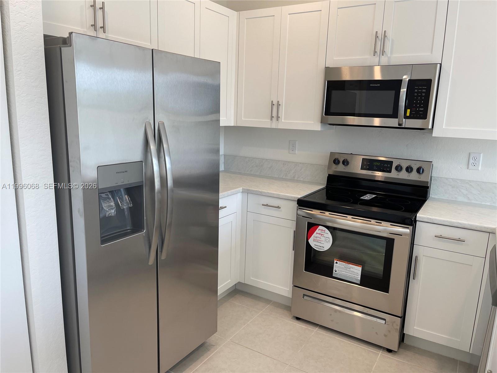 13262 Southwest 287th Terrace Homestead, FL 33033 - Photo 30 of 33 a kitchen with stainless steel appliances white cabinets and a stove