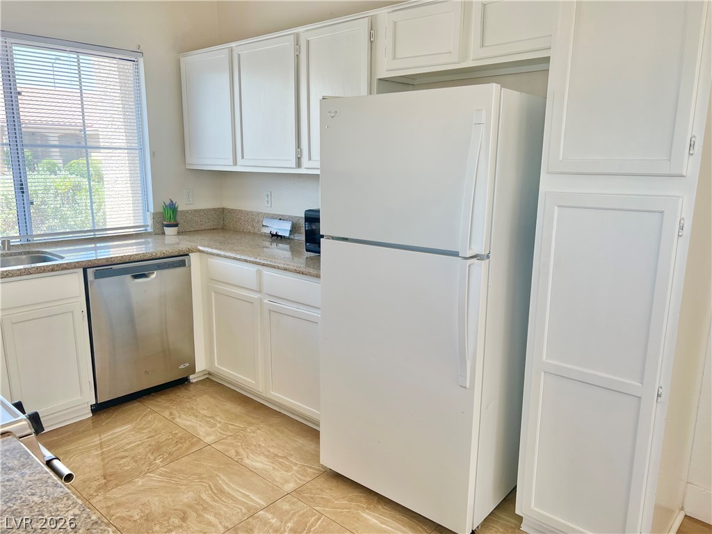 9708 Ridge Creek Place Las Vegas, NV 89134 - Photo 11 of 34 A well-appointed kitchen showcasing durable tile flooring and ample white cabinetry.