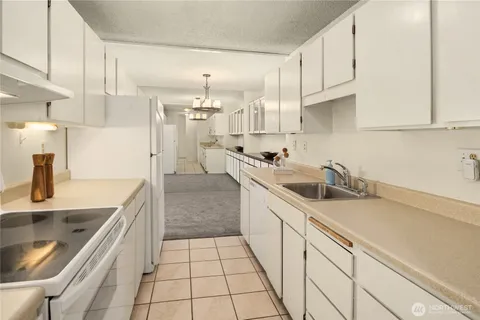 a kitchen with stainless steel appliances a sink a stove a microwave and cabinets