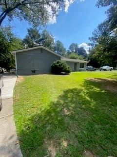 7131 Pineneedle Drive Southwest Covington, GA 30014 - Photo 1 of 1 a backyard of a house with plants and large trees