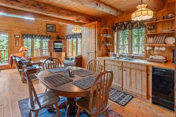 a dining room with furniture a chandelier and wooden floor