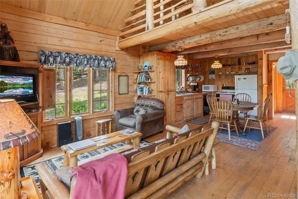 a living room with furniture a wooden floor and next to a window