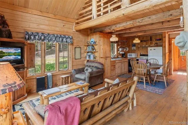 a living room with furniture a wooden floor and next to a window