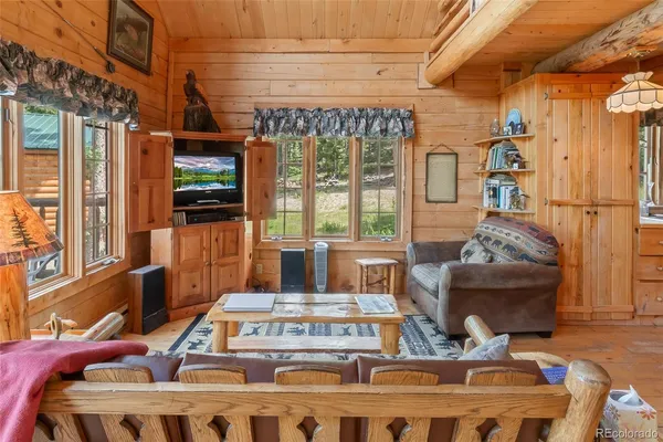 a living room with furniture a flat screen tv and a floor to ceiling window