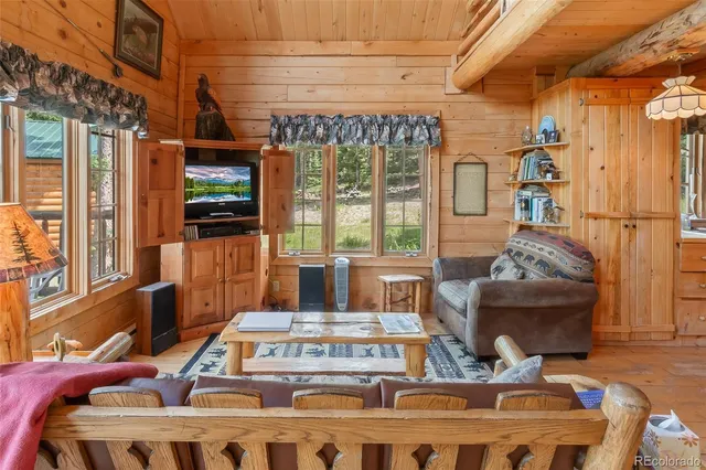 a living room with furniture a flat screen tv and a floor to ceiling window