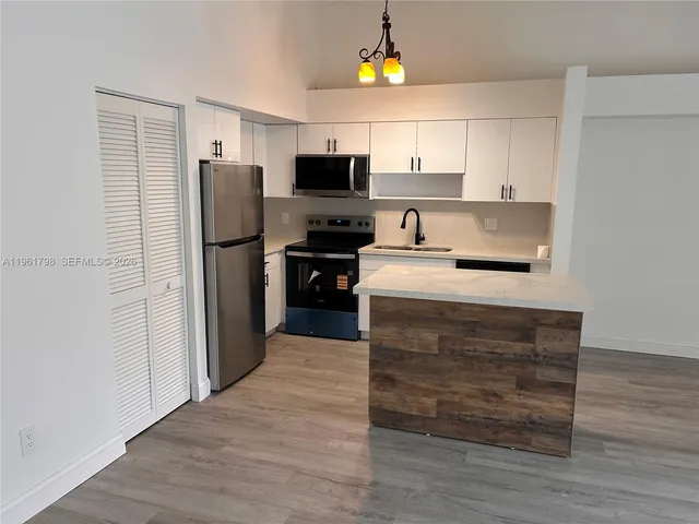 a kitchen with a refrigerator and a stove top oven