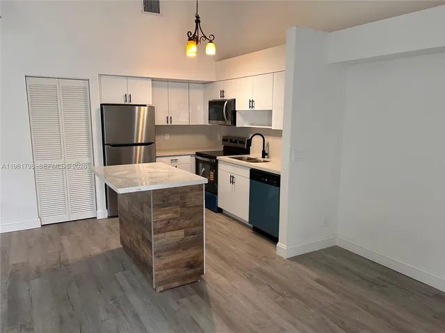 a kitchen with stainless steel appliances a refrigerator and a stove top oven