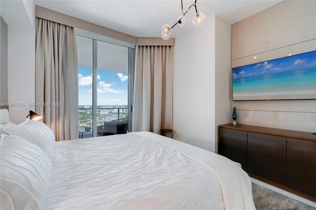 a bedroom with a large bed and a chandelier