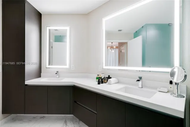 a bathroom with double vanity sinks and a mirror