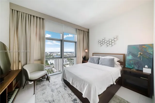 a bedroom with a bed and a couch next to a window