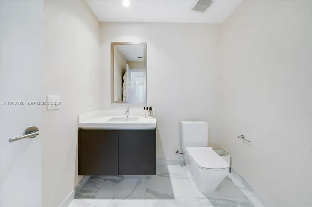 a bathroom with a sink toilet and mirror
