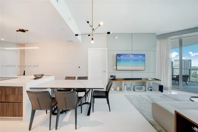 a view of a a dining table chairs and chandelier