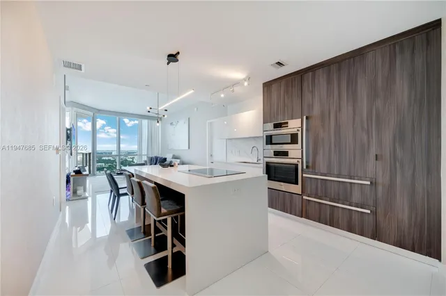 a kitchen with kitchen island a large counter top space appliances and cabinets