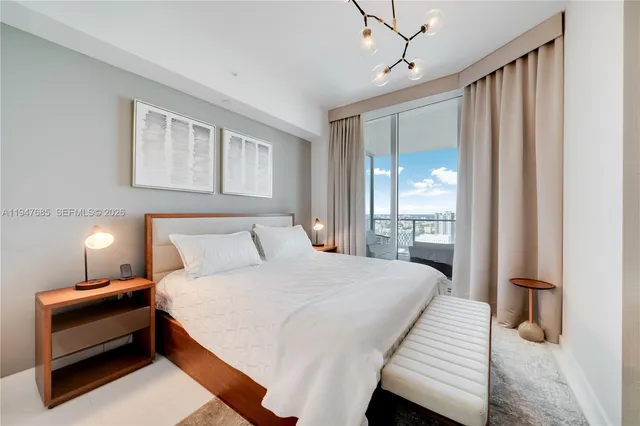 a bedroom with a bed and a chandelier