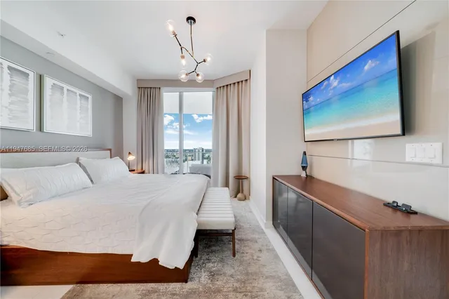 a spacious bedroom with a bed and a flat screen tv